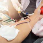 Nurse receiving blood from blood donor in hospital.