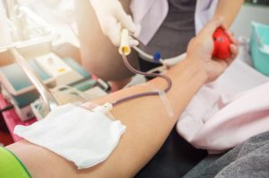 Nurse receiving blood from blood donor in hospital.